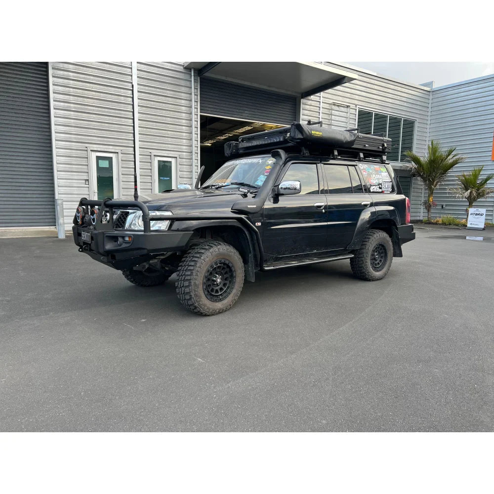 Black off-road vehicle with roof tent showcasing premium steel bullbar and fog lights