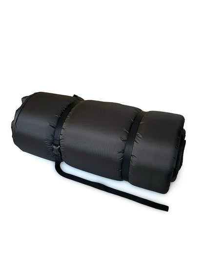Rolled-up black self-inflating mattress secured with two adjustable straps, ready for storage or transport.