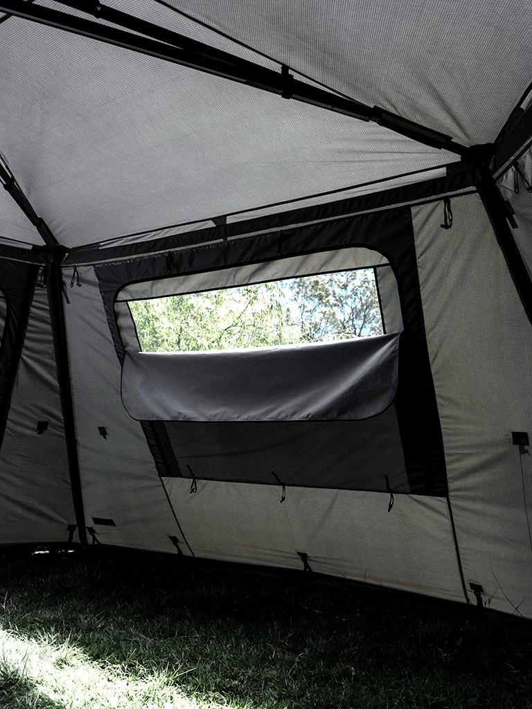 Internal view of the Lucas Creek 180 Fantail free standing awning full wall kit with the window partly down to show the mesh window behind 