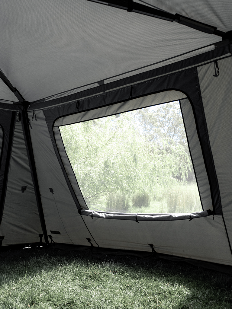 Internal view of the Lucas Creek 180 Fantail free standing awning full wall kit with the window fully rolled down to show the mesh window behind 